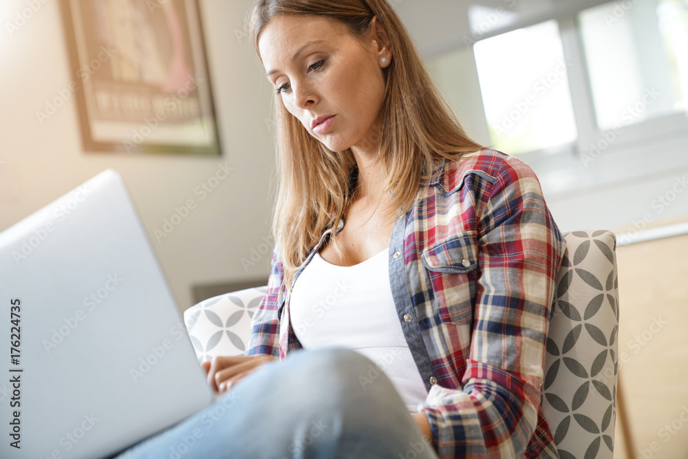 Woman with long hair using laptop at home Woman with long hair using laptop at home