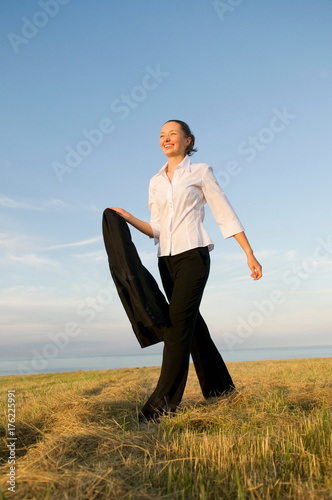 Business woman walking across a field