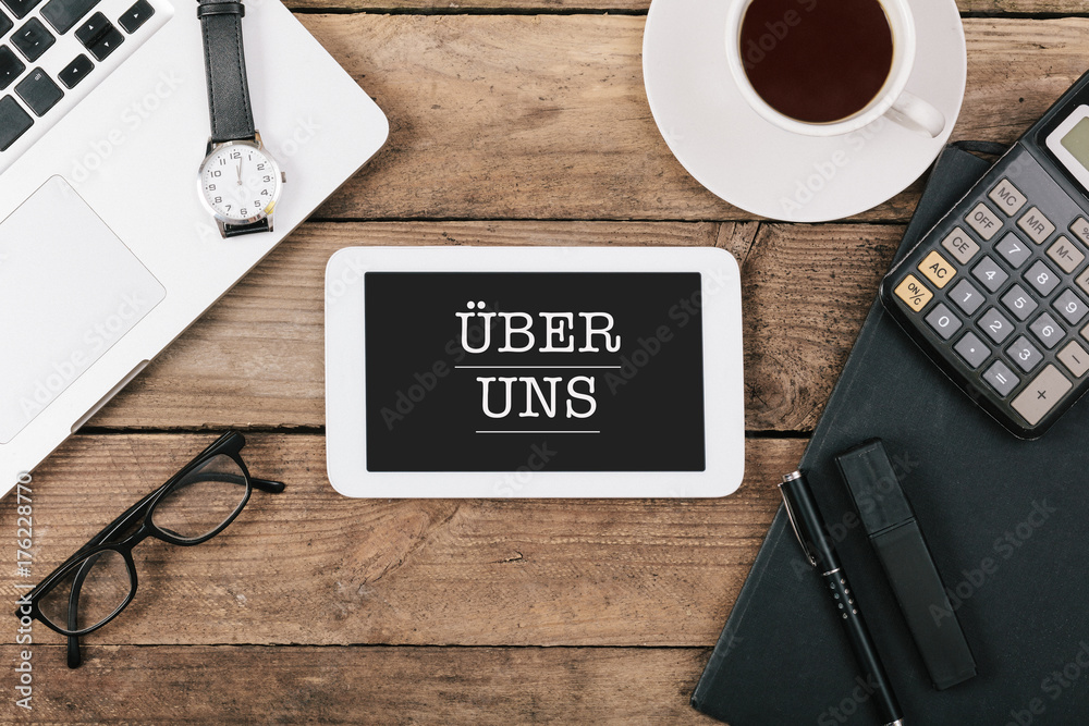 Ueber Uns auf Bildschirm eines Tablet Computers am Arbeitsplatz Ueber Uns auf Bildschirm eines Tablet Computers am Arbeitsplatz