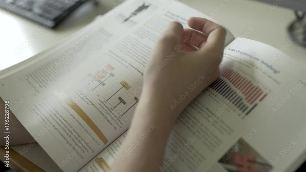 Schüler schauen sich ein Buch an - Detail auf Hand und Buch