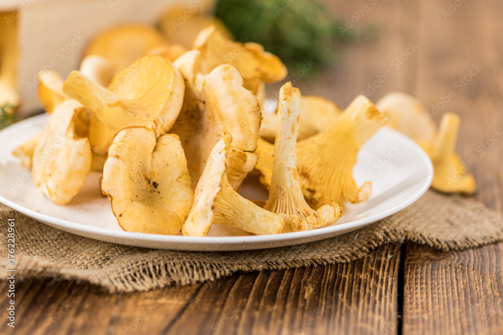 Portion of fresh harvested Chanterelles on wooden background Portion of fresh harvested Chanterelles on wooden background
