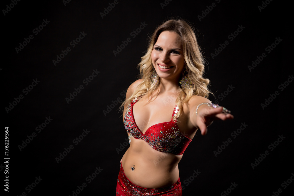 Beautiful belly dancer performing belly dance on black background. Beautiful belly dancer performing belly dance on black background.