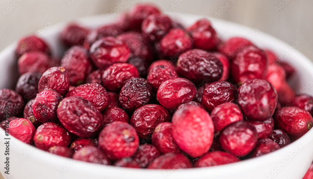Some fresh Dried Cranberries on wooden background (selective focus; close-up shot)