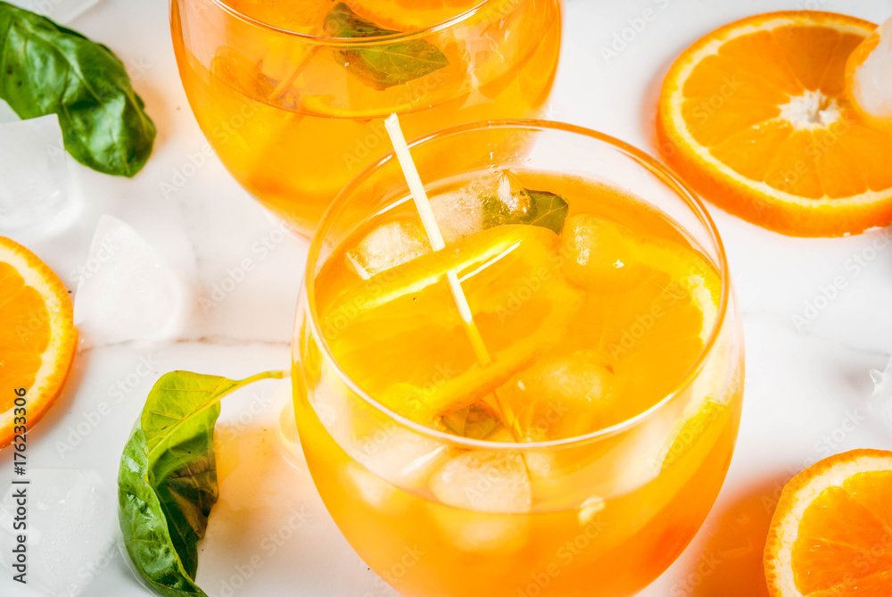 Summer refreshing drink, lemonade, cocktail with orange and basil. On a white marble table, copy space Summer refreshing drink, lemonade, cocktail with orange and basil. On a white marble table, copy space