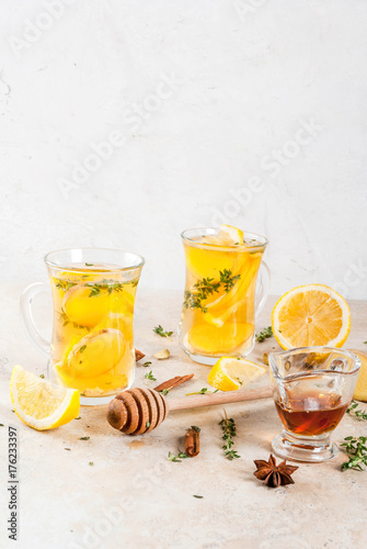 Fall and winter traditional drinks. Warming hot tea with lemon, ginger, spices (anise, cinnamon) and herbs (thyme), copy space
