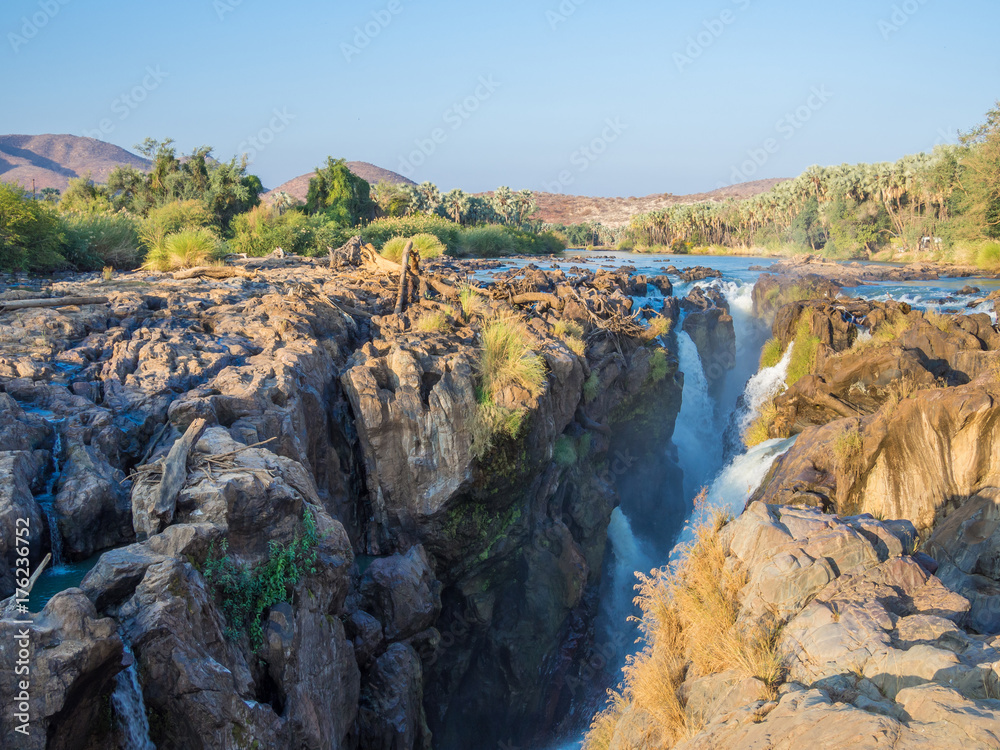 View over beautiful scenic Epupa Falls on Kunene River between Angola and Namibia in evening light, Southern Africa View over beautiful scenic Epupa Falls on Kunene River between Angola and Namibia in evening light, Southern Africa