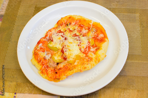 pizza made by a child on a white plate