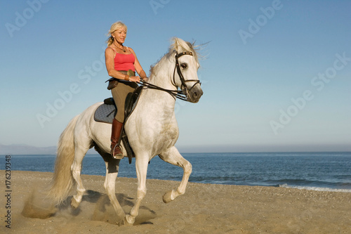 Woman riding horse on the beach
