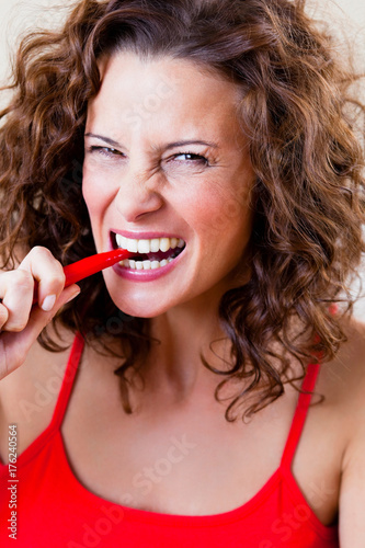Woman Biting Chili photo