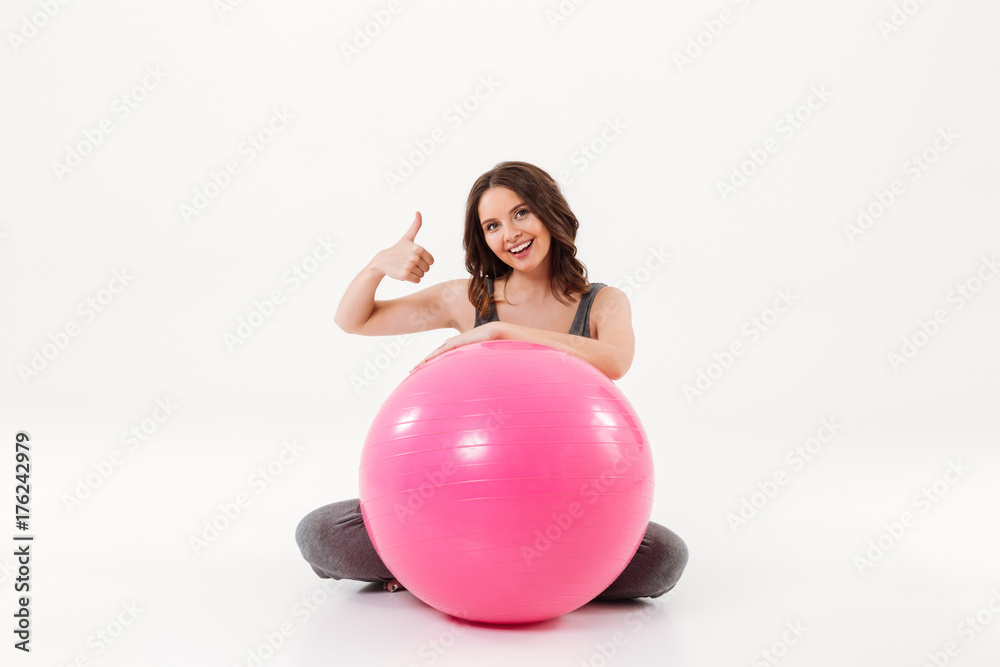 Happy pregnant woman sitting on the floor with fitball Happy pregnant woman sitting on the floor with fitball