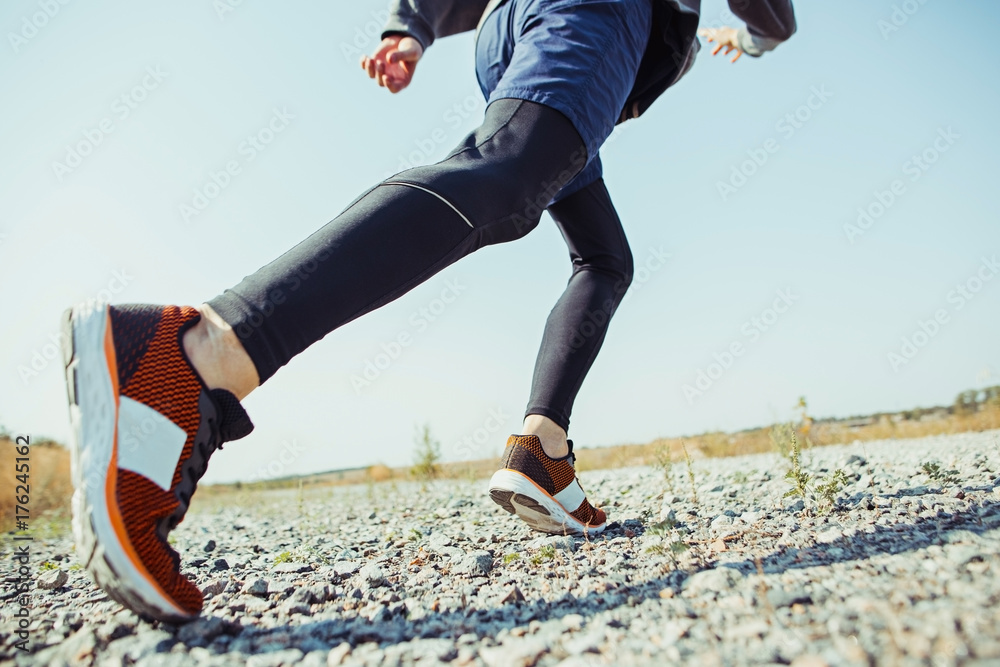Fototapeta Running sport. Man runner sprinting outdoor in scenic nature. Fit muscular male athlete training trail running for marathon run.