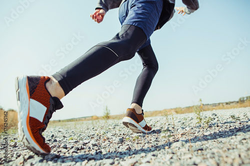 Fototapeta Naklejka Na Ścianę i Meble -  Running sport. Man runner sprinting outdoor in scenic nature. Fit muscular male athlete training trail running for marathon run.