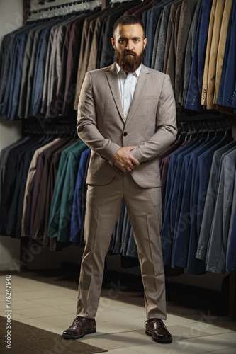 Businessman in classic vest against row of suits in shop © Gennady Danilkin
