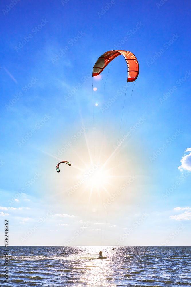 Man riding a kite surfing on the waves in the summer. Man riding a kite surfing on the waves in the summer.