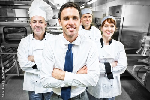 Restaurant manager posing in front of team of chefs photo