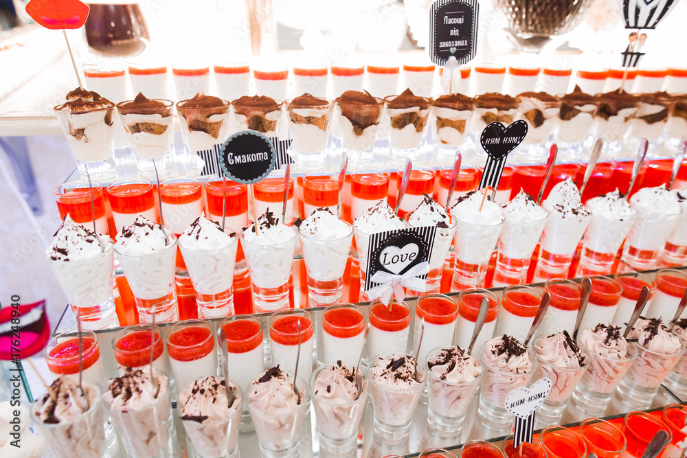 Obraz premium Delicious and tasty dessert table with cupcakes shots at reception closeup