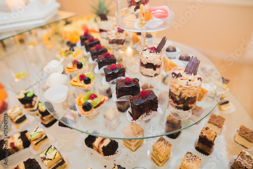 Delicious sweets on wedding candy buffet with desserts, cupcakes