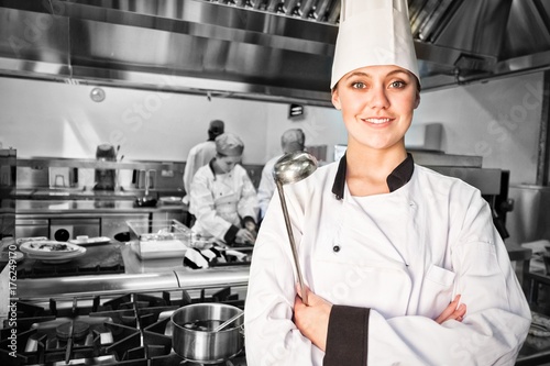 Female chef with ladle in commercial kitchen