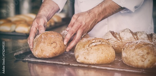 Foto Baker checking freshly baked bread