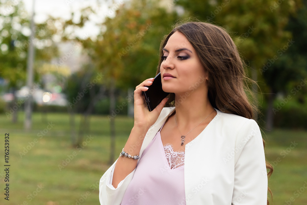 Arrogant businesswoman talking on mobile phone with the clients, partners, or suppliers. Female boss expresses grievances to the secretary or employees. Arrogant businesswoman talking on mobile phone with the clients, partners, or suppliers. Female boss expresses grievances to the secretary or employees.