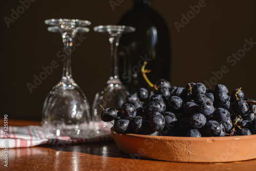 сладкий черный виноград и бокал с красным вином на столе