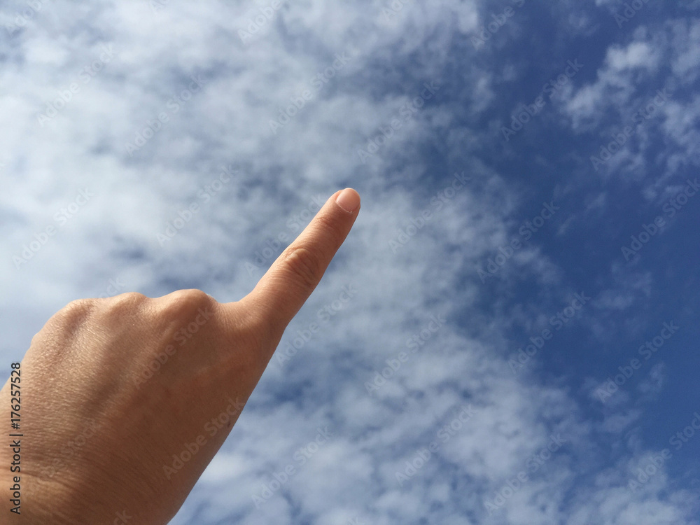 female hand touching or pointing to something on blue sky female hand touching or pointing to something on blue sky