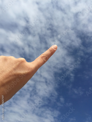 female hand touching or pointing to something on blue sky