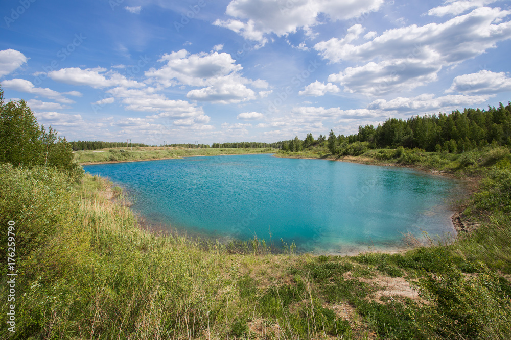 Abandoned flooded open pit quarry mine ore with blue water Abandoned flooded open pit quarry mine ore with blue water