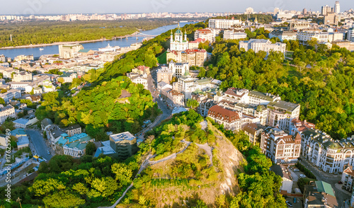 Aerial top view of Saint Andrew's church and Andreevska street from above, cityscape of Podol district on sunset, skyline of city of Kiev (Kyiv), Ukraine 