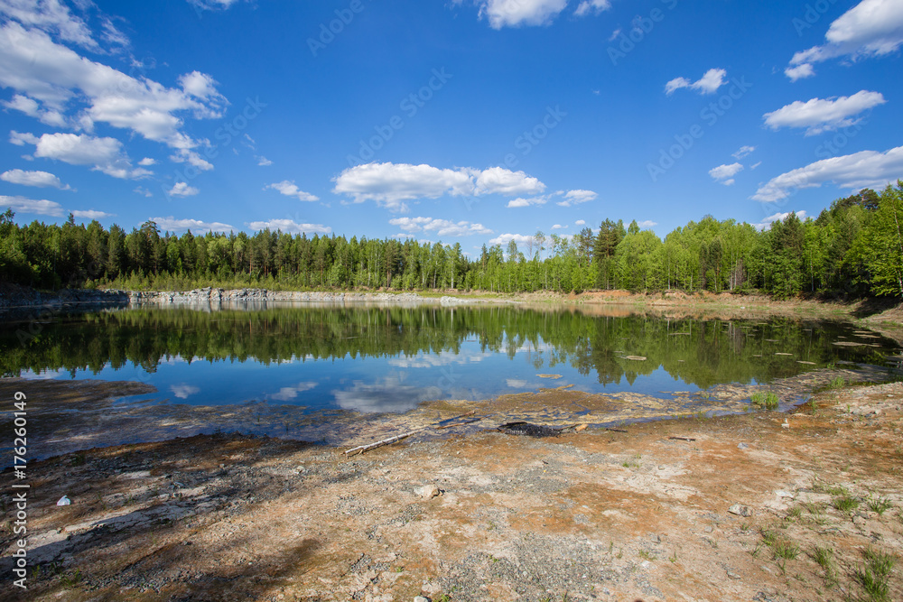 Abandoned flooded open pit quarry mine abestos ore with blue water Abandoned flooded open pit quarry mine abestos ore with blue water