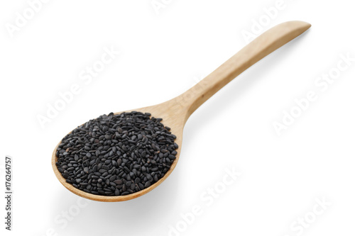 Black sesame on wood spoon on white background