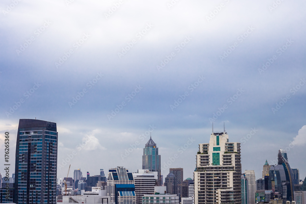 Obraz premium 沸き立つ雲にそびえ立つ都会の超高層ビルディング、クールな大都市