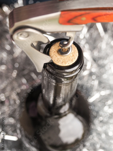 Corkscrew and bottle of red wine. Opening a bottle of wine. Close-up.
