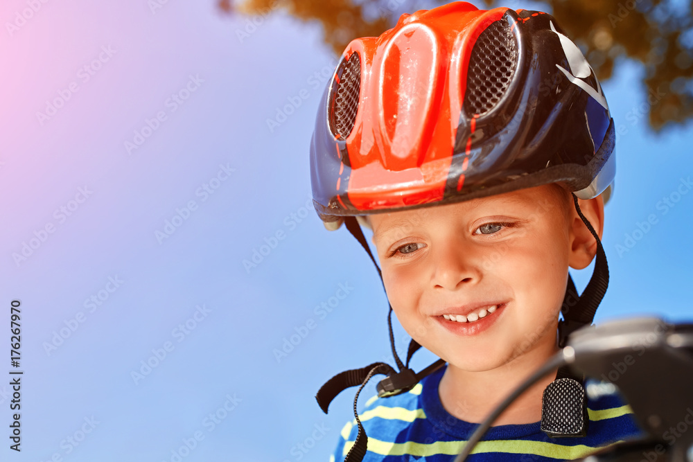 Kid with a helmet laughs happily at the park Kid with a helmet laughs happily at the park