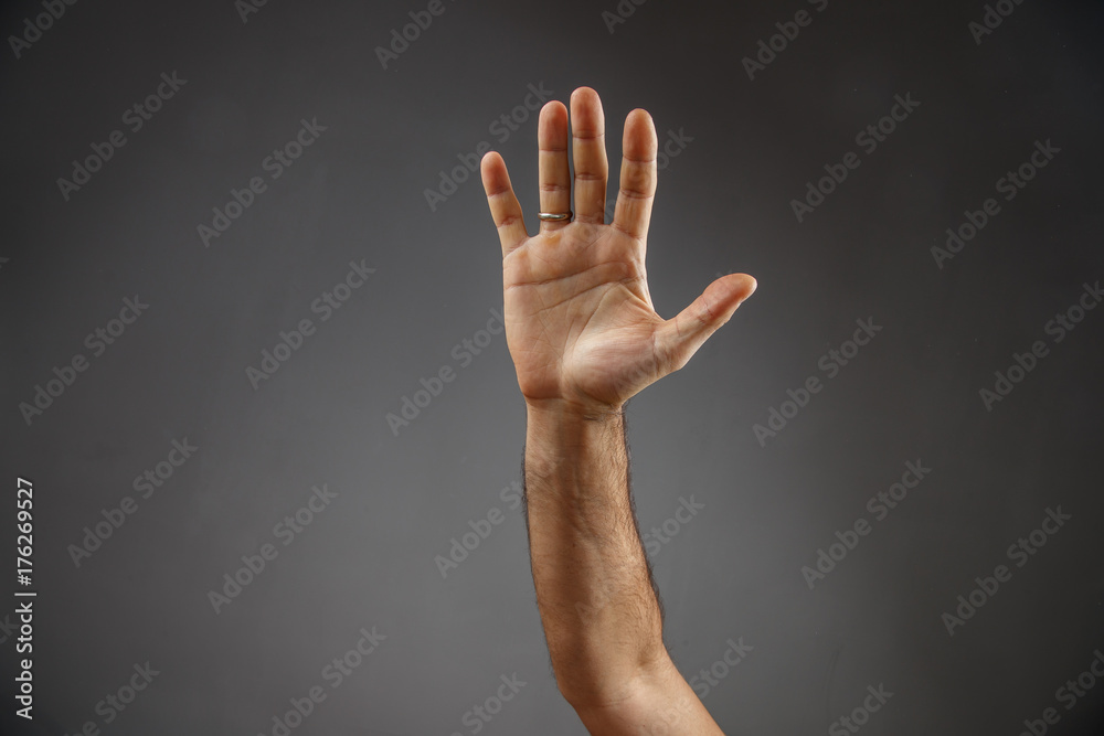 Fototapeta premium hand on a gray background. open palm