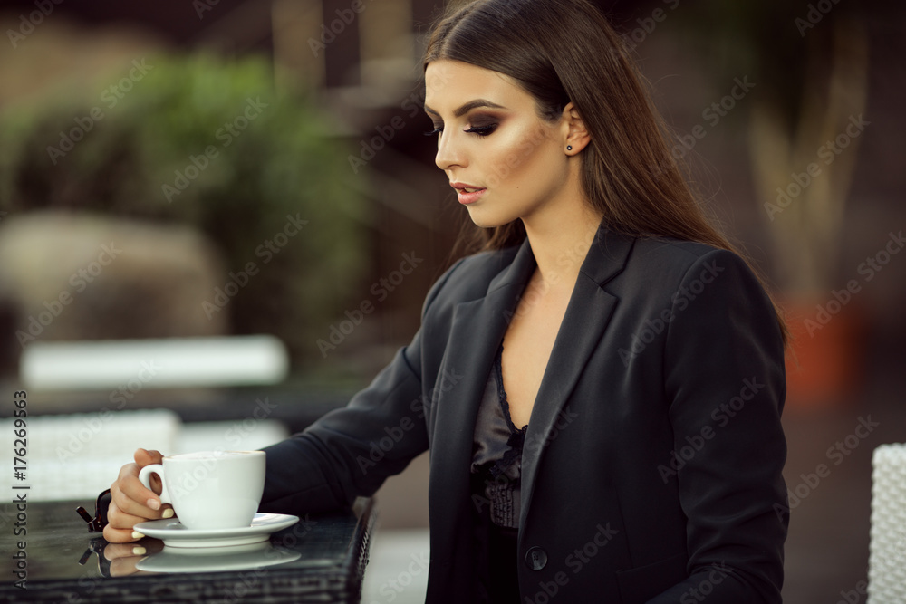Fashion business girl is wearing black official clothes drinking coffee Fashion business girl is wearing black official clothes drinking coffee