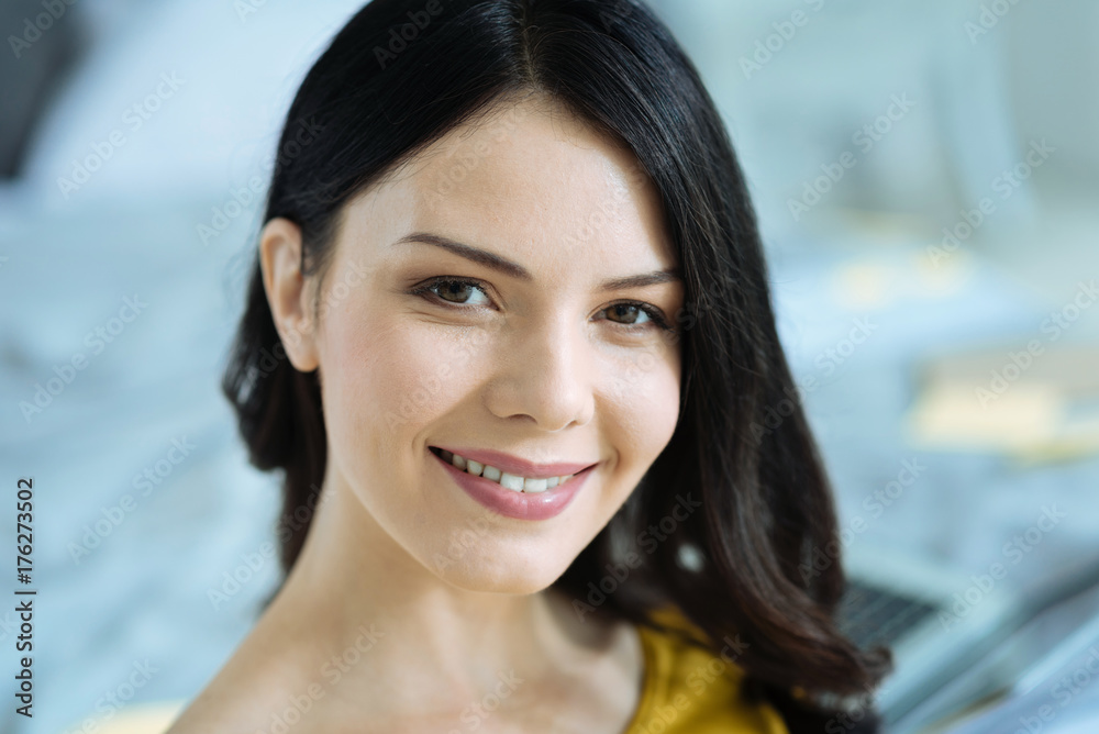 Pleasant young lady smiling into camera Pleasant young lady smiling into camera