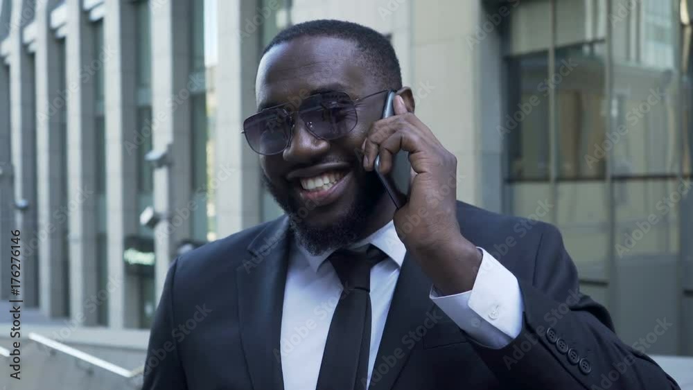 African American in business suit talking over cellphone, radiant smile, success African American in business suit talking over cellphone, radiant smile, success