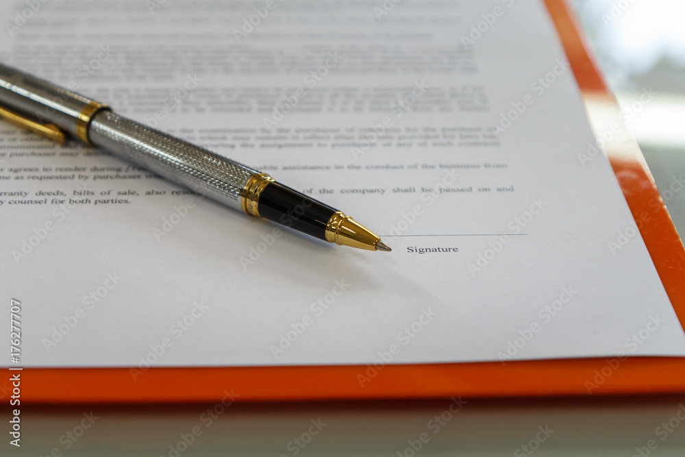 A pen on contract paper preparation for signing a contract. A pen on contract paper preparation for signing a contract.