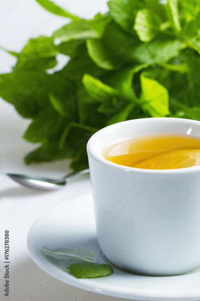 Hot mint tea with lemon on a white background Hot mint tea with lemon on a white background