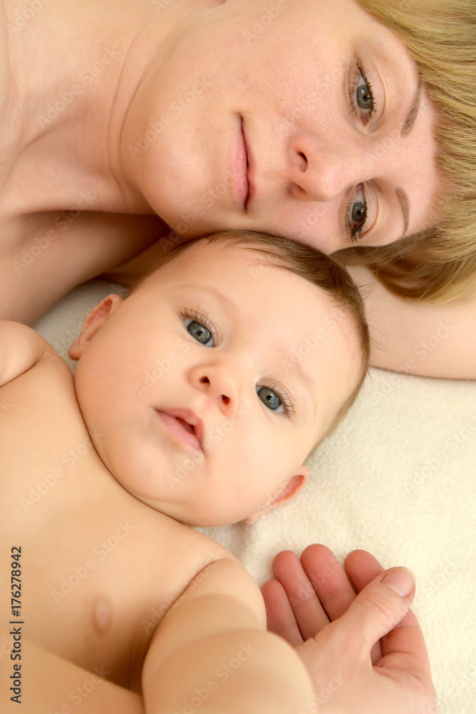 Portrait of the young woman with the baby on a light background Portrait of the young woman with the baby on a light background