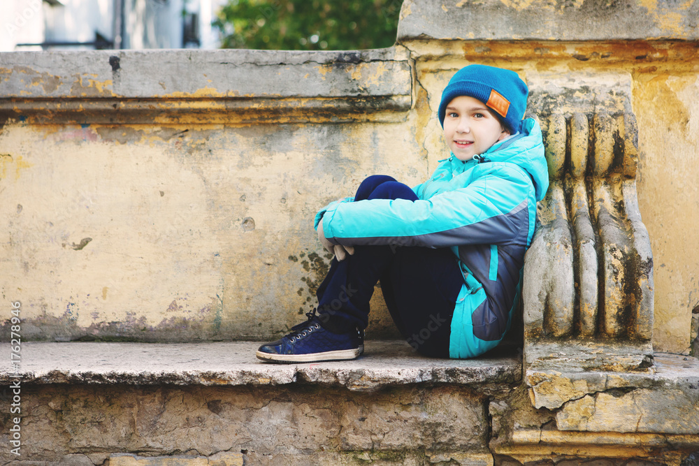 Fototapeta premium Young and happy young girl sitting on a bench in autumn Park