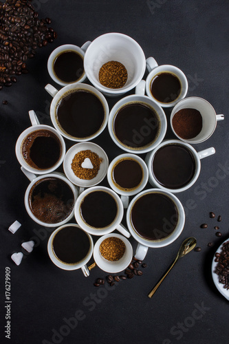 Various kind of coffee in ceramic cups on a dark table