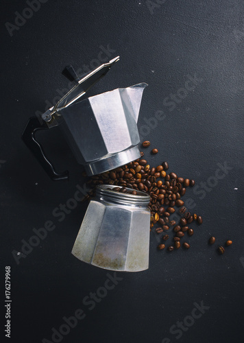 Italian percolator and coffee beans on dark background