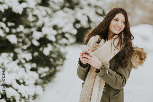 Smiling woman using phone i...
