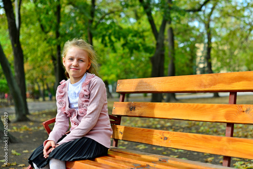 Girl sitting in a bench in the park