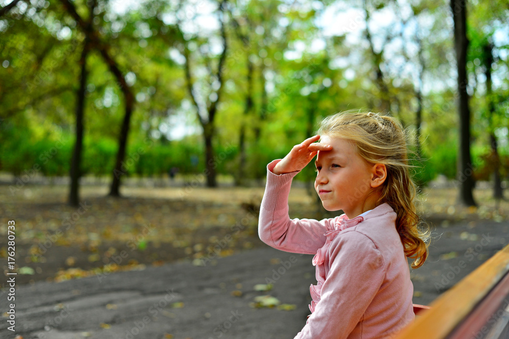 Fototapeta premium Girl sitting in a bench in the park
