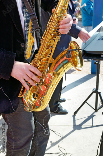 The saxophone in the hands of the musician.