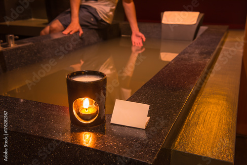 Aroma lamp with burning candle in bathroom