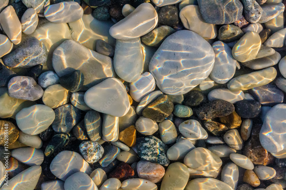 Sea stones in the sea water. Pebbles under water. The view from the top